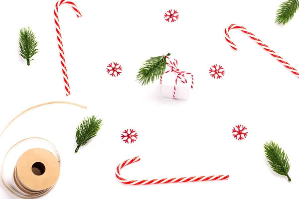 Christmas holiday layout. striped lollipops, fir branches, snowflakes and gift box on a white background — Stock Photo, Image