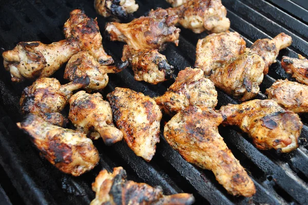 Pedaços de asas de frango em uma grelha quente de verão — Fotografia de Stock