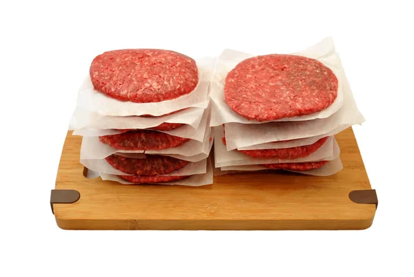 Surowej wołowiny Burgery ułożone na pokładzie cięcia drewnianych — Zdjęcie stockowe