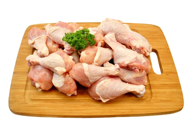 Piernas de pollo frescas crudas en un tablero de corte de madera — Foto de Stock