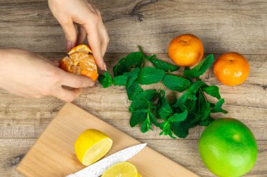 Eller mandalina dilimlenmiş limonları temizler.