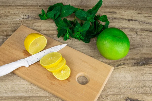 Limón en una tabla de cortar sobre una mesa de madera . — Foto de Stock