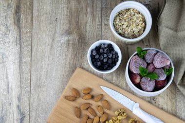 bir kasede yulaf ezmesi ve müsli, ahşap arka planda taze böğürtlen ve süt