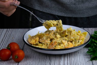 Kremalı soslu İtalyan makarnası, üzerine çatal ve çatal serpiştirilmiş baharat serpiştirilmiş karides..