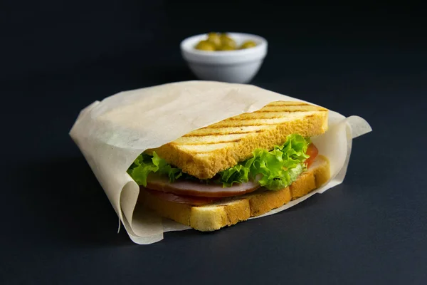 Kanapka z kilkoma kromkami białego chleba na drewnianej desce. Nadzienie kanapki składa się z sera i szynki — Zdjęcie stockowe