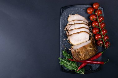 Izgara domuz bifteği ve acı kağıt ve sosla siyah taştan arka planda biberiye.