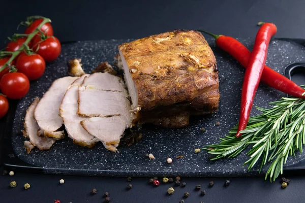 Izgara domuz bifteği ve acı kağıt ve sosla siyah taştan arka planda biberiye.