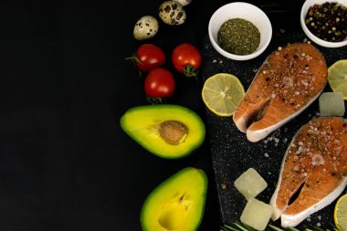 Sağlıklı dengeli süper yiyecekler, taze somon, sebze, siyah arka planda mısır gevreği.