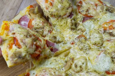 İnsanlar mozarellalı pizza parçaları çalıyor. Salam ve domates.