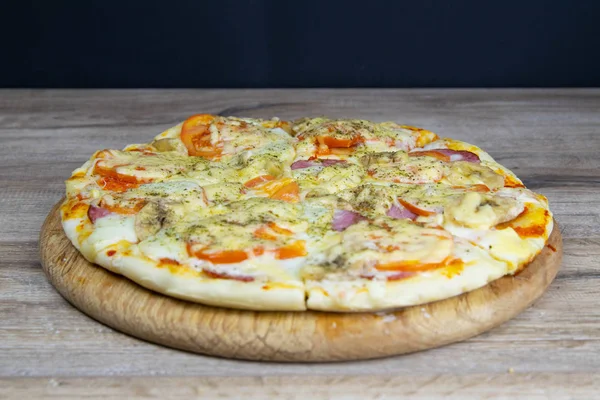 Delicious hot homemade Pepperoni pizza on the wooden table.