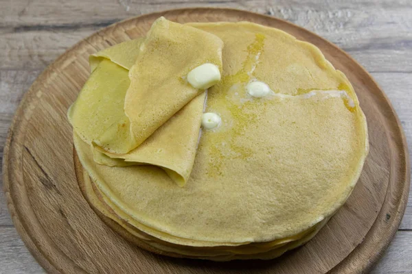 Frittelle con burro e cioccolato su tavola rotonda di legno — Foto Stock