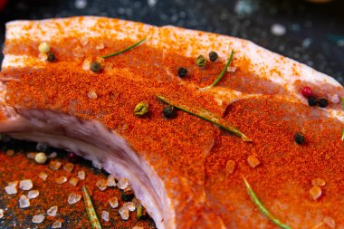 Kemiğin üzerine kırmızı biber serpiştirilmiş çiğ domuz eti, mısır, yumurta ve dolma biber..