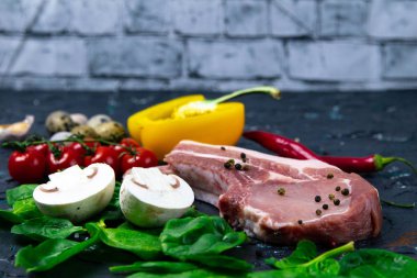 Kemiğin üzerine kırmızı biber serpiştirilmiş çiğ domuz eti, mısır, yumurta ve dolma biber.