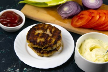 Antika ahşap plaka üzerinde düzenlenen ev yapımı hamburger malzemeler