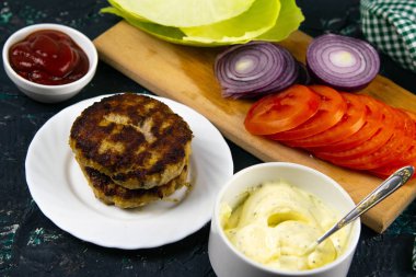 Antika ahşap plaka üzerinde düzenlenen ev yapımı hamburger malzemeler