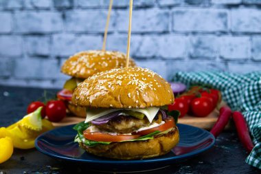 İki ev yapımı mantarlı sığır burger, mikro yeşiller, ahşap kesim tahtasındaki kırmızı soğan.