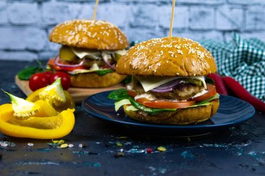 İki ev yapımı mantarlı sığır burger, mikro yeşiller, ahşap kesim tahtasındaki kırmızı soğan.