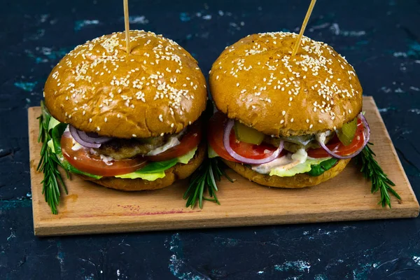 Dois hambúrgueres caseiros de carne com cogumelos, micro verdes, cebola vermelha na placa de corte de madeira — Fotografia de Stock