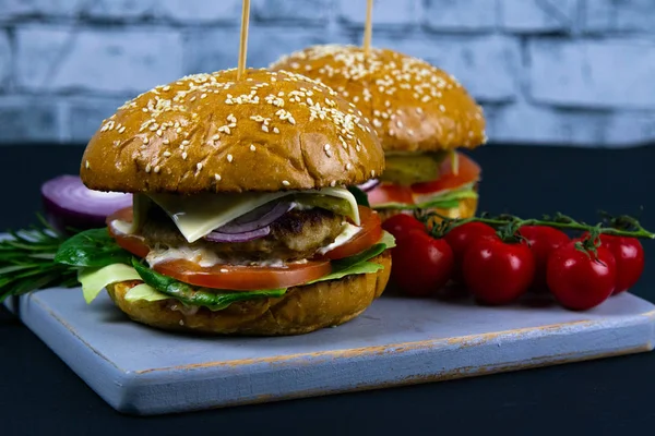 Dos hamburguesas caseras de ternera con champiñones, micro verduras, cebolla roja sobre tabla de cortar de madera —  Fotos de Stock