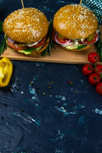 Dos hamburguesas caseras de ternera con champiñones, micro verduras, cebolla roja sobre tabla de cortar de madera — Foto de Stock