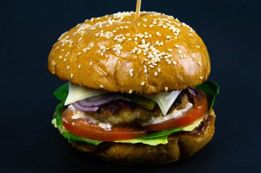 Siyah arka planda taze lezzetli bir burger.