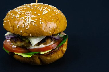 Siyah arka planda taze lezzetli bir burger.
