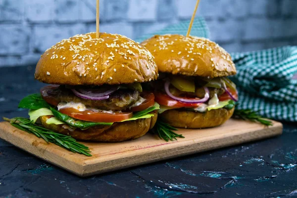 Dos hamburguesas caseras de ternera con champiñones, micro verduras, cebolla roja sobre tabla de cortar de madera — Foto de Stock