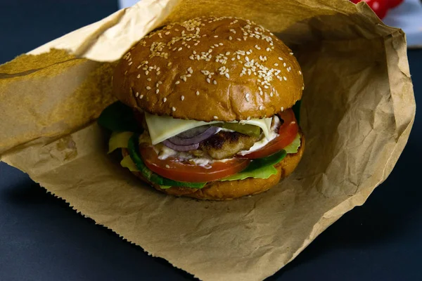 Hamburguesas en envoltorios blancos. Antigua mesa de madera con hamburguesas. Lechuga jugosa y bollos calientes . — Foto de Stock