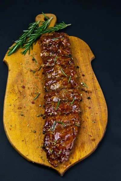 Barbecue Pork Spare Ribs with rosemary as top view on an old cutting board — Stok fotoğraf
