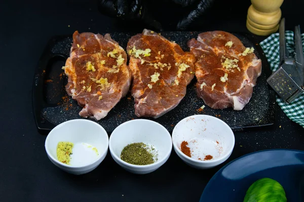 Pork steaks seasoned with red pepper, spices and frequent. Fresh raw pork tenderloin on a wooden cutting board. — 스톡 사진