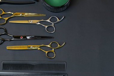 Koyu arka plan üzerine düzenlenmiş profesyonel kuaför araçları koleksiyonu