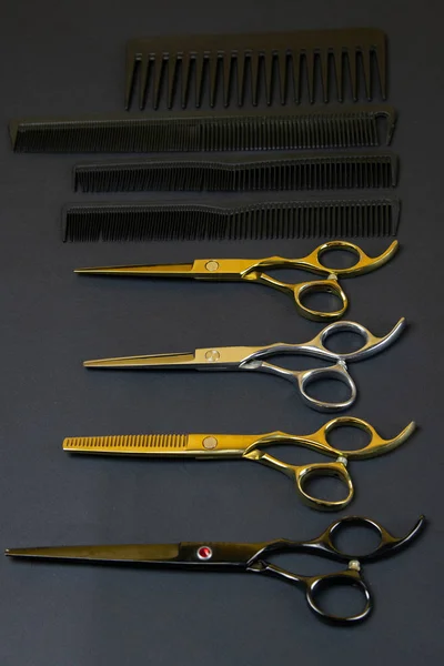 Kolekcja profesjonalnych narzędzi do fryzjerów ułożonych na ciemnym tle — Zdjęcie stockowe