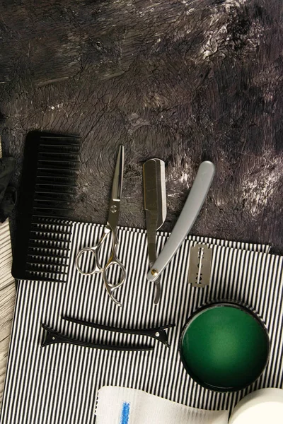 Colocación de herramientas para barbero, tijeras, navaja peligrosa, cuchilla, rocío y gel de pelo verde en una hermosa toalla a rayas — Foto de Stock