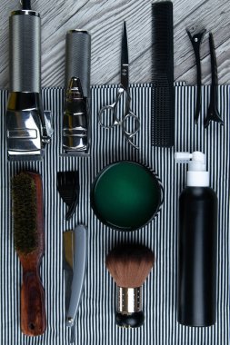 Saç kesimi, makas, tarak, saç şekillendirme ve tıraş için jel de dahil olmak üzere kuaför aksesuarları düz yatıyordu.