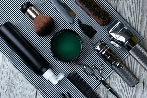 Flat lay from hairdressing accessories including: haircuts, scissors, combs, gels for styling and shaving laid