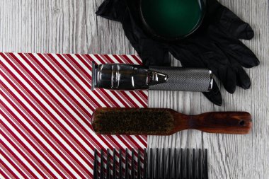 Tarak, saç kesim makinesi, ve siyah eldivenler güzel çizgili kırmızı beyaz arka plan