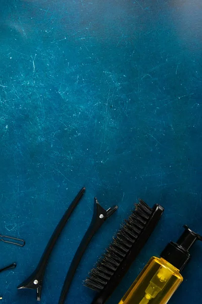 Peines, horquillas, gel para el cabello y espárragos para el cabello dispuestos sobre un hermoso fondo azul mármol — Foto de Stock