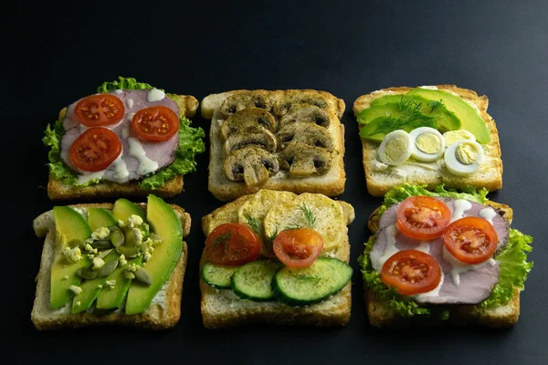 Kombinacja z różnymi rodzajami kanapek: z grzybami, z awokado i jajami, z szynką — Zdjęcie stockowe