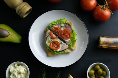 Lezzetli sandviçler, marul ve jambonla ikiye bölünmüş, yakın plan beyaz tabakta..