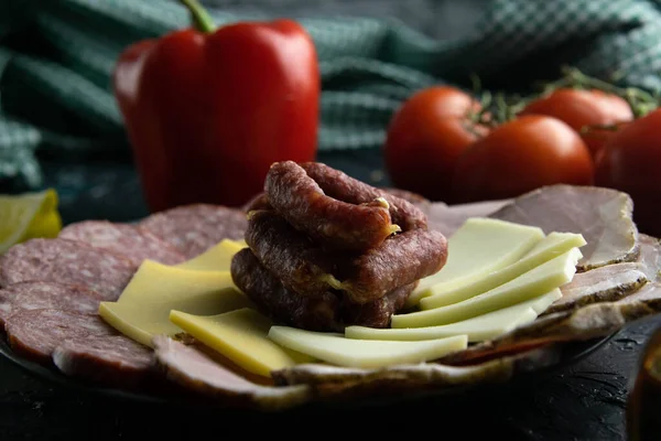 Plato gris con salchichas alrededor del salami, jamón, queso y mozzarella. Tomate, souce, aceitunas, limón, aceite de oliva con especias — Foto de Stock