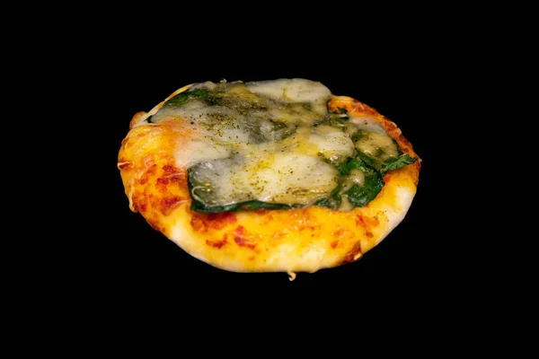 Невелика міні піца зі шпинатом та сиром ізольована на чорному тлі — стокове фото