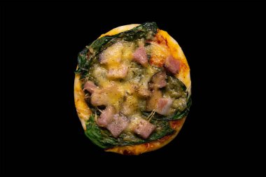 Ispanaklı, Becky 'li ve peynirli küçük bir pizza. Siyah arka planda.