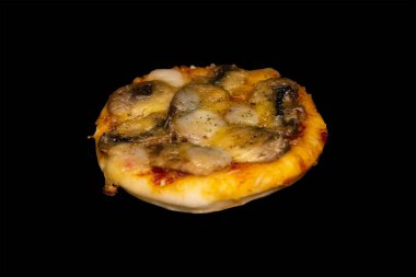 Siyah arka planda mantarlı ve peynirli küçük bir pizza.