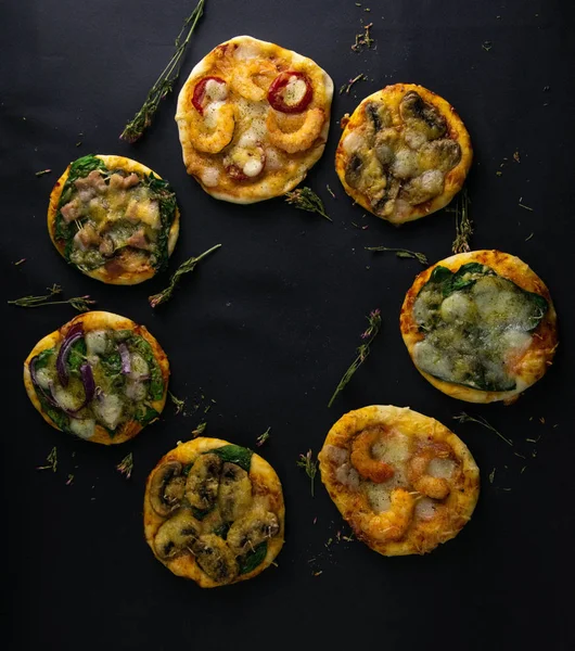 Küçük mini pizza. Farklı mini pizzalar. Pizza: karidesli, mantarlı, ıspanaklı, soğanlı, pastırmalı, kağıtlı, domatesli. — Stok fotoğraf