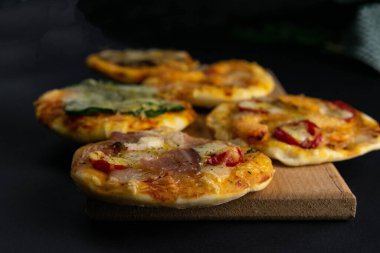 Küçük mini pizza. Farklı mini pizzalar. Tahta üzerinde pizza: karidesli, mantarlı, ıspanaklı, soğanlı, pastırmalı, kağıtlı, domatesli