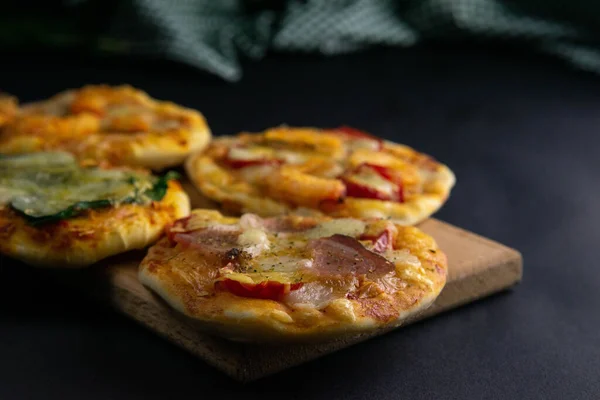 Küçük mini pizza. Farklı mini pizzalar. Tahta üzerinde pizza: karidesli, mantarlı, ıspanaklı, soğanlı, pastırmalı, kağıtlı, domatesli — Stok fotoğraf