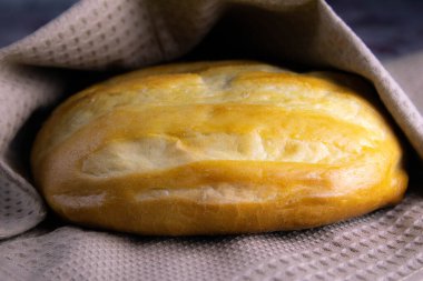 Doğal güneş ışığı altında beyaz havluyla ev yapımı ekmek.