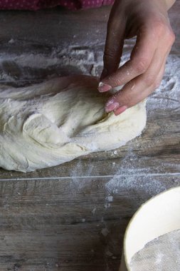 Kadınların elleri hamuru ahşap bir masada karıştırıyor. Pişirmek için ekmek hazırlıyorum.