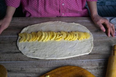 Dilimlenmiş elma ve tarçın, teste yayılmış.