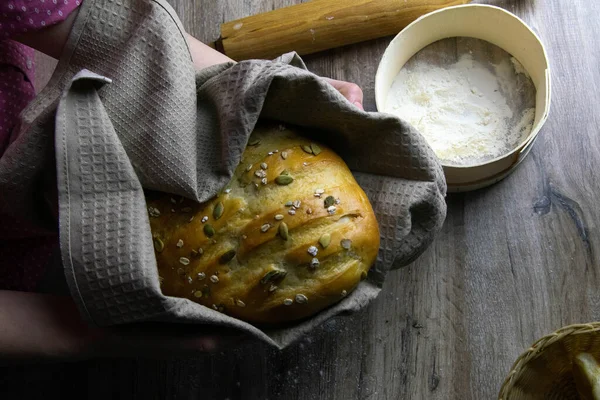 Closeup of fresh rustsic bread in a woman's hand — Stock Photo, Image